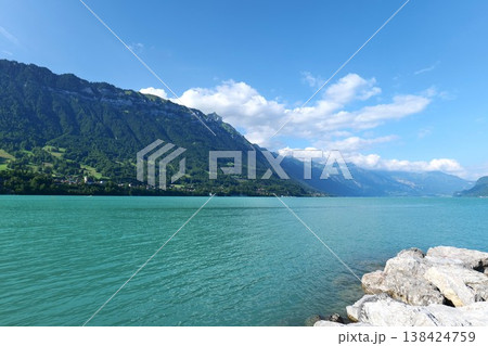 Scenic Turquoise Lake Surrounded by Green Mountains under Blue Sky in Switzerland Scenic Turquoise Lake Surrounded by Green Mountains under Blue Sky in Switzerland 138424759