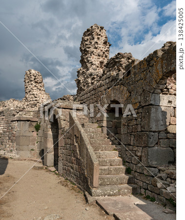 Historic Acropolis of Pergamon ruins with stone walls, arches, and staircase under cloudy sky, Bergama Turkey Historic Acropolis of Pergamon ruins with stone walls, arches, and staircase under cloudy sky, Bergama Turkey 138425005