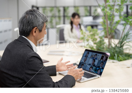 オンライン会議で打ち合わせをするビジネスマンと女性社員 138425080