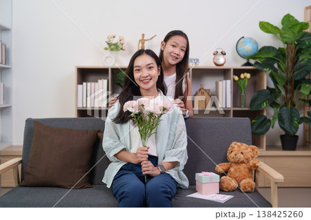 Mother receiving flowers and gifts from her daughter on Mother's Day Mother receiving flowers and gifts from her daughter on Mother's Day 138425260
