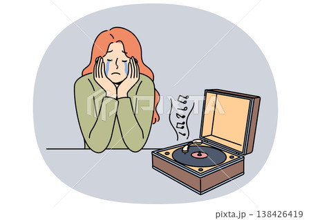 Woman cries while listening to music on vinyl player, due to nostalgia and memories of happy past 138426419