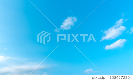 Clear blue sky with soft white clouds drifting gently Clear blue sky with soft white clouds drifting gently 138427220