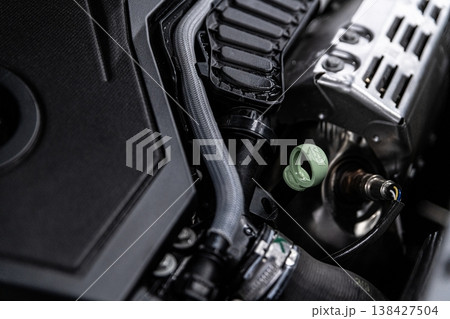Engine oil dipstick check in car engine bay measuring oil level in modern vehicle close-up 138427504