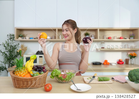 Woman holding fresh fruits in a modern kitchen Woman holding fresh fruits in a modern kitchen 138428527