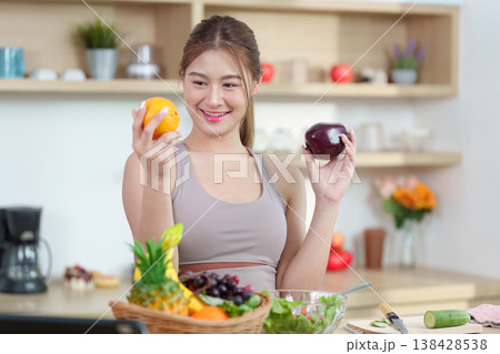 Woman comparing fruits in a modern kitchen Woman comparing fruits in a modern kitchen 138428538