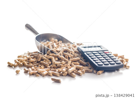 Calculator on Pile of Wood Pellets Representing Biofuel Cost, Renewable Energy Accounting and Fuel Efficiency Analysis Calculator on Pile of Wood Pellets Representing Biofuel Cost, Renewable Energy Accounting and Fuel Efficiency Analysis 138429041