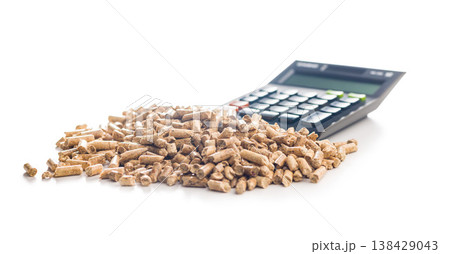 Calculator on Pile of Wood Pellets Representing Biofuel Cost, Renewable Energy Accounting and Fuel Efficiency Analysis 138429043