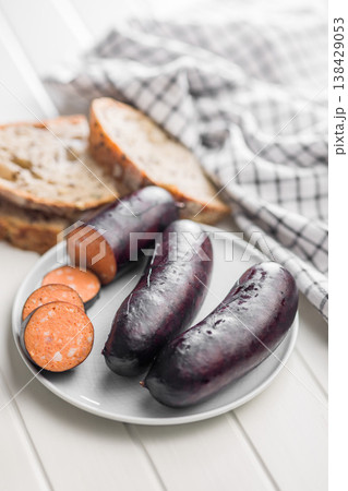 Smoked Blood Sausage Sliced on Plate with Bread and Kitchen Towel in Rustic Style 138429053