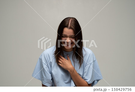 Young woman laughing heartily, experiencing happiness and joy, expressing genuine positive emotions 138429756
