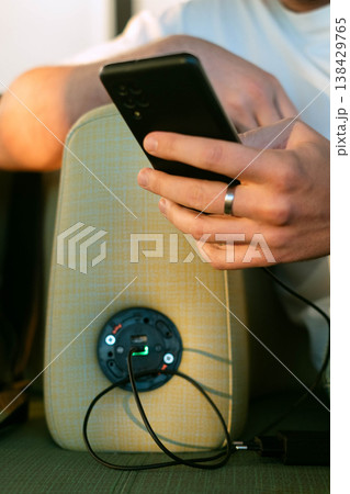 Man charging smartphone in airport seat using built in station ability to work anywhere key to flexible and mobile lifestyle and constant connection Man charging smartphone in airport seat using built in station ability to work anywhere key to flexible and mobile lifestyle and constant connection 138429765