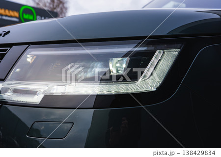 Close up of the front left LED matrix headlamp on a Range Rover Autobiography outside a workshop, cool daylight and shallow depth of field emphasize geometry and finish. Close up of the front left LED matrix headlamp on a Range Rover Autobiography outside a workshop, cool daylight and shallow depth of field emphasize geometry and finish. 138429834