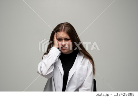 Young woman experiencing severe headache and migraine, showing emotional distress, sadness, and stress 138429899