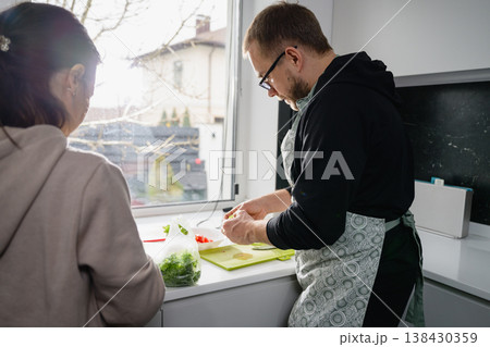 Couple preparing fresh vegetables together in home kitchen Couple preparing fresh vegetables together in home kitchen 138430359