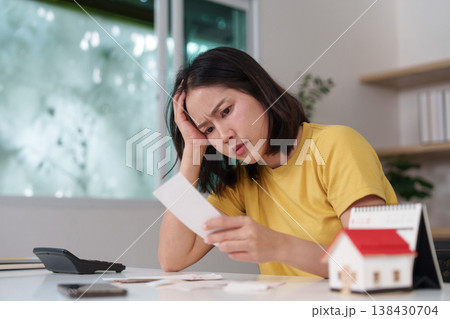 Woman reviewing bills with concern 138430704