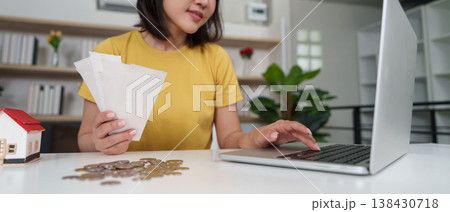 Woman paying bills online with laptop 138430718