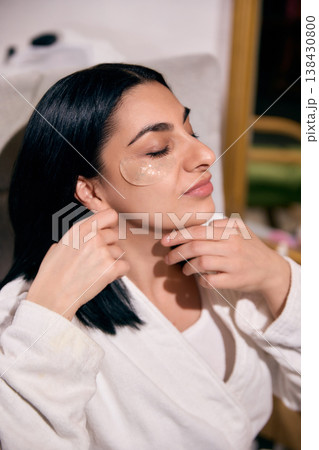 Relaxed woman with under eye patches during beauty routine. 138430800