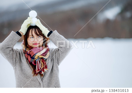 雪だるまを持つ若い女性 138431013