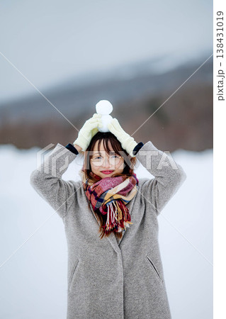 雪だるまを持つ若い女性 雪だるまを持つ若い女性 138431019