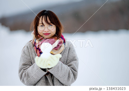 雪だるまを持つ若い女性 雪だるまを持つ若い女性 138431023
