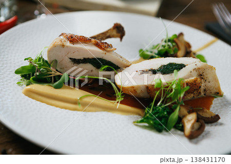 Indulge in our Gourmet Stuffed Chicken Breast, perfectly paired with a flavorful Herb Sauce 138431170