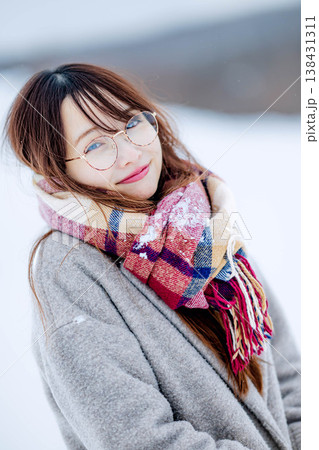 雪の中楽しむコートを着た若い女性 雪の中楽しむコートを着た若い女性 138431311