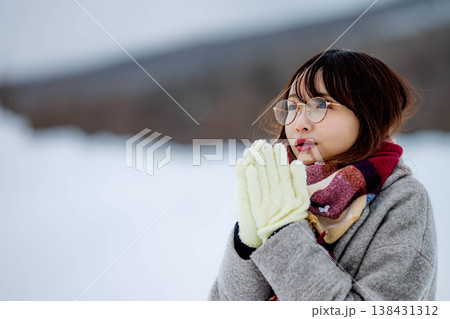 雪の中楽しむコートを着た若い女性 雪の中楽しむコートを着た若い女性 138431312
