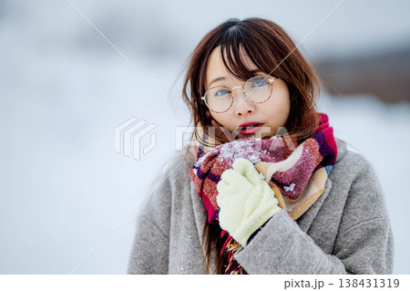 雪の中楽しむコートを着た若い女性 138431319