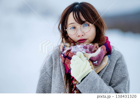 雪の中楽しむコートを着た若い女性 138431320