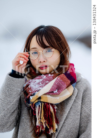 雪の中楽しむコートを着た若い女性 138431324