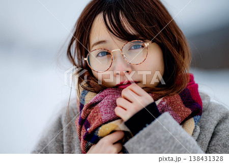 雪の中楽しむコートを着た若い女性 138431328