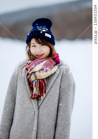 雪の上に立つ笑顔の女性 138431504