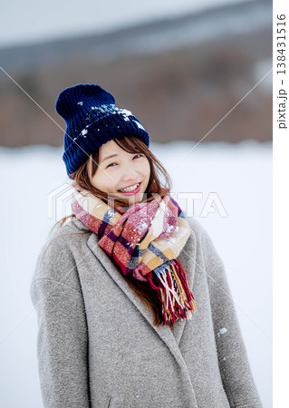 雪の上に立つ笑顔の女性 138431516
