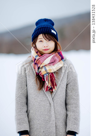 雪の上に立つ笑顔の女性 138431528