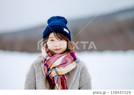 雪の上に立つ笑顔の女性 138431529