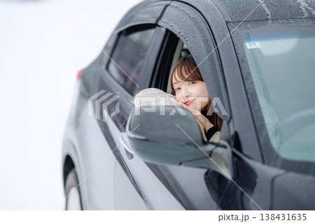 冬の雪の中で車を運転する若い女性 冬の雪の中で車を運転する若い女性 138431635