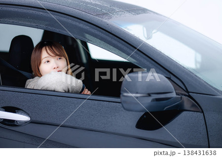 冬の雪の中で車を運転する若い女性 138431638
