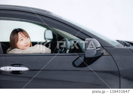 冬の雪の中で車を運転する若い女性 冬の雪の中で車を運転する若い女性 138431647