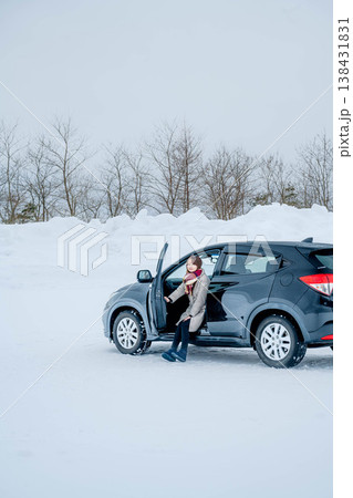 冬の雪の中車に乗る若い女性 138431831