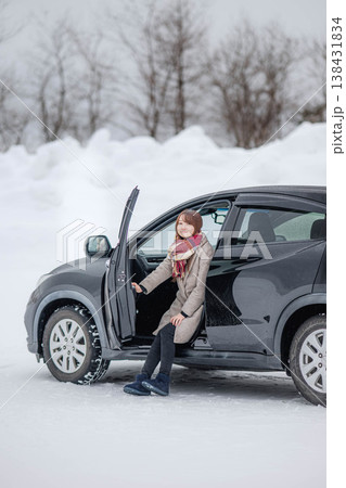 冬の雪の中車に乗る若い女性 冬の雪の中車に乗る若い女性 138431834
