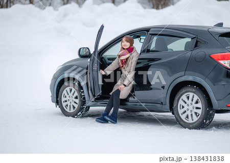 冬の雪の中車に乗る若い女性 138431838