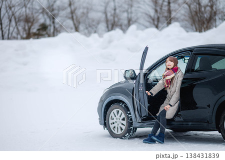 冬の雪の中車に乗る若い女性 冬の雪の中車に乗る若い女性 138431839