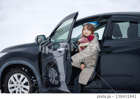 冬の雪の中車に乗る若い女性 138431841