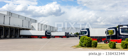 Modern blue cargo truck delivery van parked logistics warehouse center complex building exterior bay. Semi-trailer lorry unload goods distribution blue sky. Cargo storage facility industry building Modern blue cargo truck delivery van parked logistics warehouse center complex building exterior bay. Semi-trailer lorry unload goods distribution blue sky. Cargo storage facility industry building 138432344