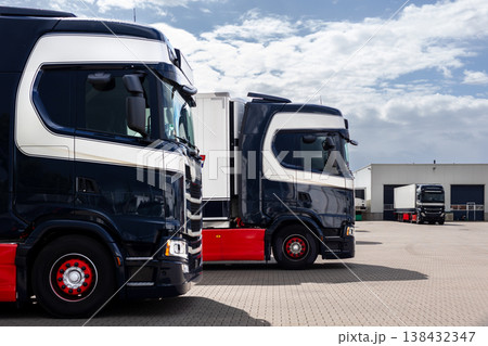 Modern blue cargo truck delivery van parked logistics warehouse center complex building exterior bay. Semi-trailer lorry unload goods distribution blue sky. Cargo storage facility industry building 138432347