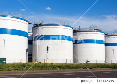 Row many large industrial fuel storage white tanks clear blue sky background on sunny day. Oil storage refinery depot liquid facilities. Energy hazmat railroad transportation storage and distribution Row many large industrial fuel storage white tanks clear blue sky background on sunny day. Oil storage refinery depot liquid facilities. Energy hazmat railroad transportation storage and distribution 138432349