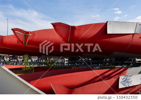 Massive red wind turbine blades resting industrial support manufacturing site blue sky. Renewable energy equipment components prepared transport installation future power generation infrastructure Massive red wind turbine blades resting industrial support manufacturing site blue sky. Renewable energy equipment components prepared transport installation future power generation infrastructure 138432350