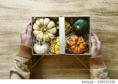 Autumn pumpkins gift box in hands Autumn pumpkins gift box in hands 138432536