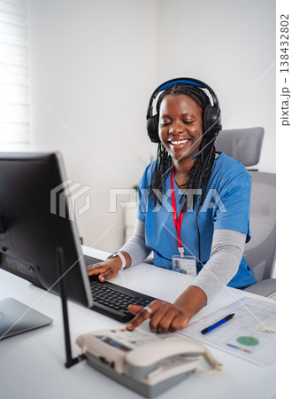 African American female nurse wearing headset doing telehealth consultation African American female nurse wearing headset doing telehealth consultation 138432802