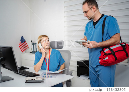 Medical team conversing during busy work shift at clinic Medical team conversing during busy work shift at clinic 138432805