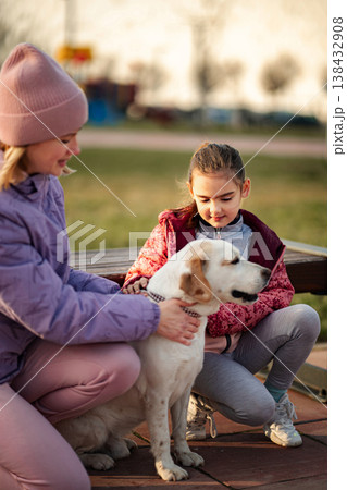Children petting dog in park feeling happy at sunset Children petting dog in park feeling happy at sunset 138432908